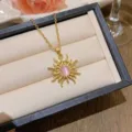 Elegant gold sunburst necklace featuring a round pink opal pendant in jewelry box. - X0263-1 Gold Sunray Style (Pink Stone) / Gold