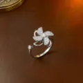 Silberner drehbarer Windrad-Blumenring mit funkelnden Zirkonia auf Lederhintergrund - Ring (J0016) / Stahlfarben