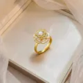Elegant gold-plated camellia flower ring with pearl and micro-pave zircon details. - Gold Micro-Inlaid Zirconia Artificial Pearl Camellia Ring (J1201)