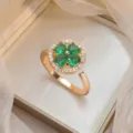 Elegant rotating green four-leaf clover ring with gold finish and zircon pavé halo - Clover Rotating Ring (J0023) / Gold Green