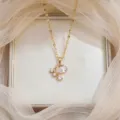 Elegant gold necklace featuring a pink teardrop zircon pendant and white stone accents - Pink Water Drop Zirconia (X0688)