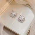 Silver-tone square checkerboard stud earrings with sparkling pavé zircon accents. - Checkered Zirconia Earrings (E0474)