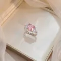 Elegant pink square zircon ring with triangular side stones and a silver-tone finish. - Square Pink Rhinestone Ring (J0245)