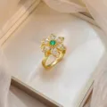 Luxury gold-plated flower ring with an emerald-green center and sparkling zircons - Green Main Stone Micro-inlaid Flower Ring (J1206)