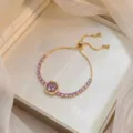 Elegant gold plated titanium steel bracelet featuring purple zircon flower charm - Bauhinia Rotating Bracelet (TS0016) / Gold Purple
