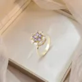 Elegant gold-plated rotating flower ring featuring purple and white sparkling zircon stones - Purple Zirconia Rotating Ring (J0763) / Gold