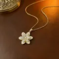 Eine vergoldete Halskette mit drehbarem Zirkonia-Blumenanhänger auf braunem Leder - Emaille Blumenhalskette (X0059) / Gold