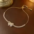 Elegantes goldenes verstellbares Armband mit einem rotierenden Zirkonia Blumenanhänger - Rotierendes Blumenarmband (TS0187) / Gold