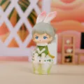 Gros plan d'une figurine de petit garçon mignon avec des oreilles de lapin pour bureau - Garçon Assis / Figurines décoratives