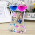Detaillierte Makroansicht der herzförmigen Flüssigkeits-Sanduhr mit rosa blauen Tropfen. - Doppelherz Windmühle / Blau + Rosa