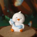 Close-up detail of a cute white duck figurine holding a blue vintage telephone on a wood stump - Holding Blue Phone / White Duck B (Retro Phone Style)