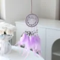 Détail de l'attrape-rêves en pierre de cristal violette avec plumes délicates et perles tissées. - Violet