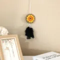 Détail d'un attrape-rêve tournesol avec des plumes noires sur un mur beige chaud - Blanc