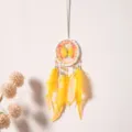 Close-up detail of hanging dreamcatcher with yellow feathers and butterfly ornament for interior. - Lemon Yellow