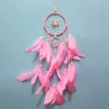 Vue détaillée de l'attrape-rêves rose fait main avec des plumes et perles pour déco murale. - Coupe régulière / Rose