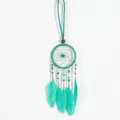 Detailed macro view of ethnic turquoise dreamcatcher necklace with feathers and beads - Mint Green