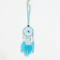 Vue détaillée d'un pendentif attrape-rêves bleu style ethnique avec plumes et perles fines. - Bleu ciel