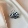 Close-up of elegant swan brooch with blue crystals and rhinestones on satin background. - Swan