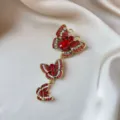 Close-up macro detail of a vintage triple butterfly brooch with red rhinestones on silk - Three-Tier Vintage Butterfly Style (903)