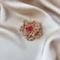 Elegant gold-tone flower brooch featuring a vibrant pink central crystal and pavé rhinestones. - Pink Faceted Flower Style (891) / Pink Iridescent Rhinestone