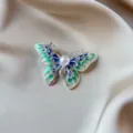 Detailed view of vintage butterfly brooch with green enamel and pearl centerpiece - Green Butterfly