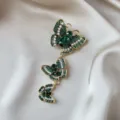 Detailed macro view of vintage gold-tone brooch with three green crystal butterflies - Vertical Decreasing Three-Tier Butterfly Style (909)