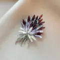 Elegant feather brooch with purple and white marquise crystals on beige fabric background - 1007