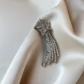 Elegant silver shooting star brooch with sparkling rhinestones on luxurious silk background. - Meteor Tassel Style (832) / Silver Star