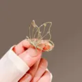 Gold hollow butterfly brooch detail, elegant metal clothing accessory for coats. - Hollow Butterfly / Gold