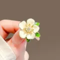 Close-up of an elegant creamy white gardenia brooch with pearl and rhinestone details - Gardenia Brooch