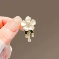 Elegant white flower brooch with sparkling crystals and green leaves for women fashion accessory. - Daisy / White
