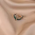 Close-up detail of a sparkling rhinestone whale brooch with elegant green enamel finish - Whale / Green