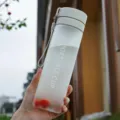 Frosted plastic water bottle with portable strap, ideal for outdoor sports and travel use. - Matte Grey
