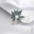 Detail view of an elegant green maple leaf brooch featuring a center pearl accent - Blue Maple Leaf Style (#36)