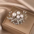 Close-up detail of the elegant pearl and crystal brooch featuring shimmering rhinestones. - Leaf Pearl / Gold