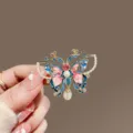 Macro detail of an ornate enamel painted butterfly brooch with faux pearls and crystals - Colorful Butterfly