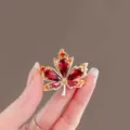 Elegant red crystal maple leaf brooch for women, sparkling rhinestone fashion jewelry accessory. - Red Maple Leaf