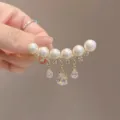 Close-up detail of luxury pearl brooch featuring sparkling water drop crystal tassels - Smile Teardrop Style