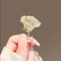 Macro shot of a luxury rose brooch fully paved with sparkling crystals in gold finish. - Rose