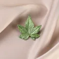 Close-up macro shot showing the fine texture of the green leaf brooch on beige satin - Light Green Brushed Leaf (662#)