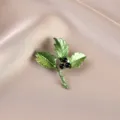 Macro view of elegant green holly leaf brooch featuring black berries on satin fabric - Holly Leaf with Black Berries (675#)
