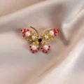 Detailed view of an elegant butterfly brooch with colorful rhinestones and pearls - Gradient Red and Green Butterfly Style (752#)