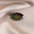 Elegante vintage oog broche met sprankelende zwarte en blauwe strass stenen in goud. - Oog #702