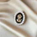 Elegant vintage cameo brooch with golden portrait and pearl border on satin background - Vintage Cameo Profile Style (850) / Black/Gold