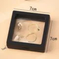 Black 3D floating frame jewelry display box set with elegant gold tone earrings and rings. - 7x7cm Jewelry Box