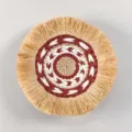 Close-up of the woven wall hanging featuring detailed bohemian fringe and concentric patterns. - C8
