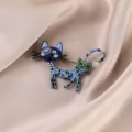 Close-up of a colorful cartoon cat brooch with heart patterns and a green bow detail - Blue Cat / Blue