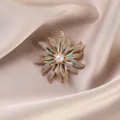 Elegant gold-tone flower brooch with sparkling rhinestones and center pearl for women. - Flower / Gold