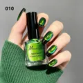 Primo piano dello smalto verde cat eye con manicure luccicante coordinata su unghie lunghe - Smalto Occhio di Gatto Dopamina 10