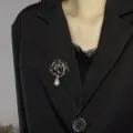 Camellia pearl brooch detail shot, elegant black suit lapel pin, delicate winter accessory. - Black